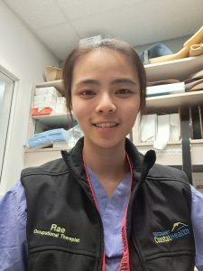 Rae smiling into the camera from inside a splinting room