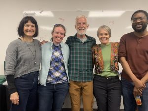 Five linguists and family smiling